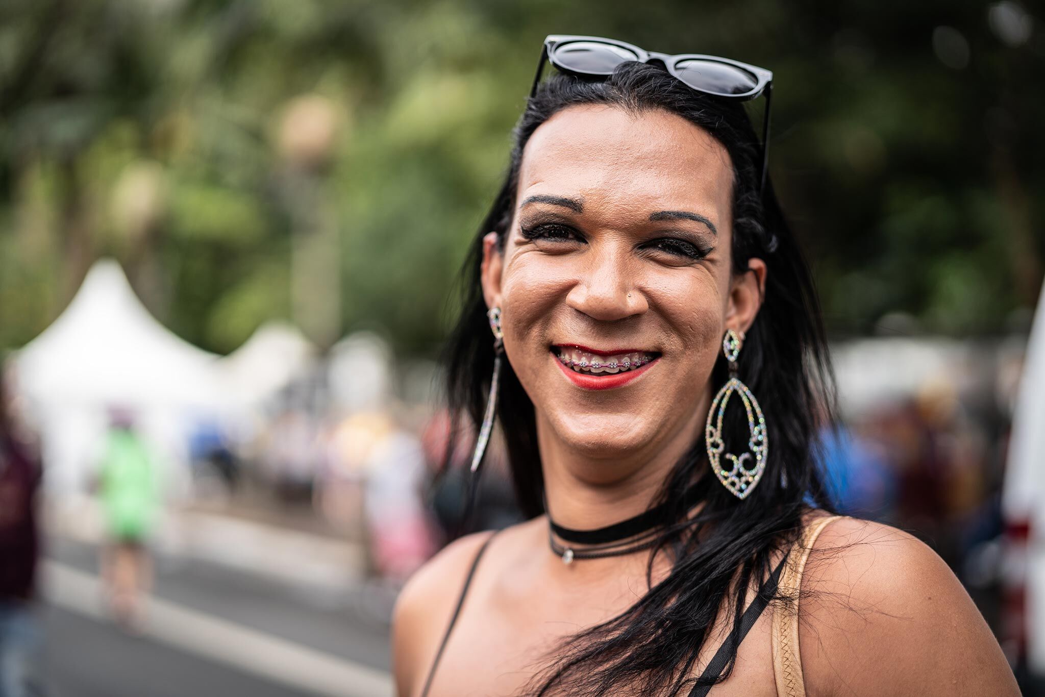 inset-photo-3 Portrait of a gender fluid person smiling while attending an outdoor festival.